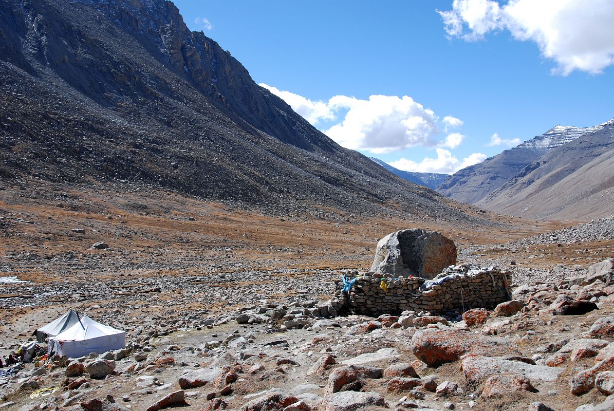 59 Eastern Valley After Descent From Dolma La With A Buddha Footprint Imbedded On Top Of Large Boulder On Mount Kailash Outer Kora The trail took an hour to reach the Eastern Valley (5235m,10:15) from the Dolma La. To the right of the trail beside a stone wall is Buddha footprint imbedded on top of the boulder. The pilgrims who run the seasonal nomad refreshment tent were packing up for the seasons and heading home.